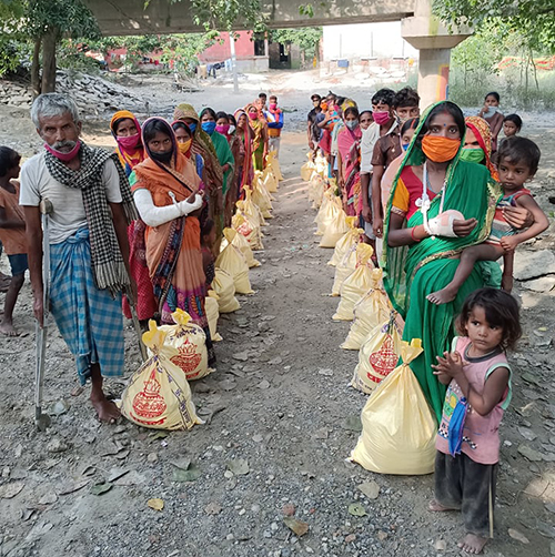 Villagers with their food packets, which will last one week per family